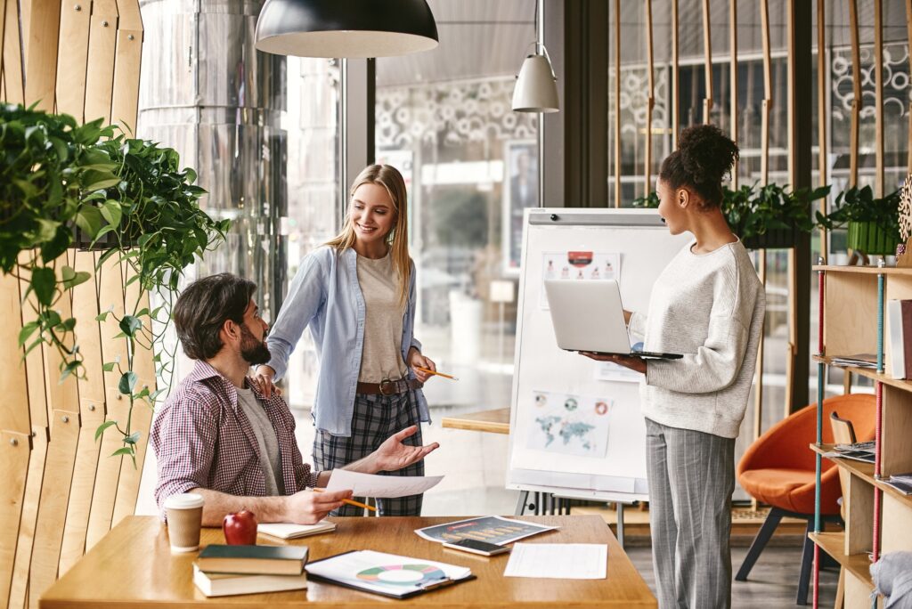 Discussing company progress. Three co-workers are comparing results and developing a strategy